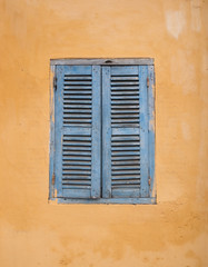 Fototapeta na wymiar Retro window on the yellow wall in Hoi an, Vietnam