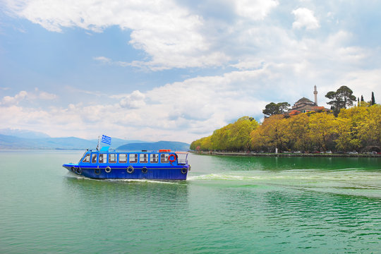 Greece, ferry boat with greek flaf crossing the lake of Ioannina