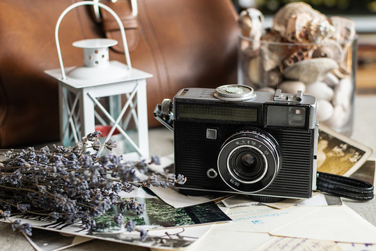 Beautiful vintage composition with old camera, bouquet of dry lavender, black and white photos and old letters.  