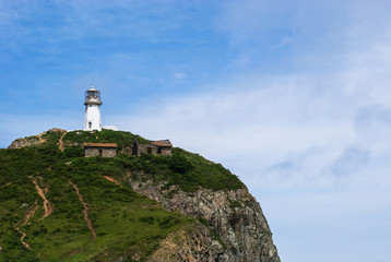 Fototapeta na wymiar Cape Briner. Primorsky Krai. lighthouse Rudny on top of a hill near the shore of the Japan sea