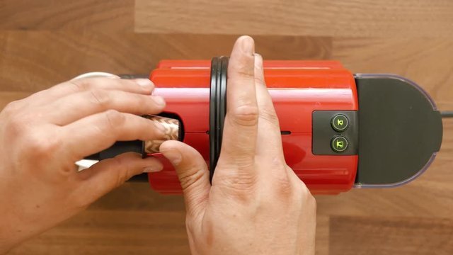 Top shot of espresso coffee maker. Mans hand put a capsule and mug and presses the button