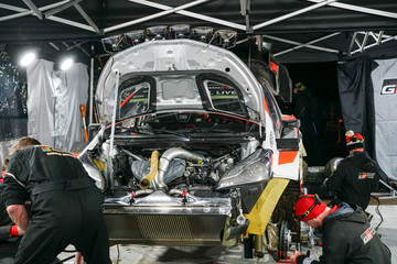 Mechanics making the last preparations to the rally car before leaving to the race