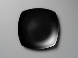 Top view empty black plate on grey background with shadow