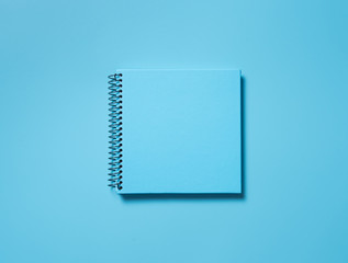 Blue note book on blue background with shadow