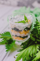 Exotic salad with nettles and eggs in a glass lined in layers.