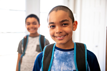 A child boy coming home passing through the door after school
