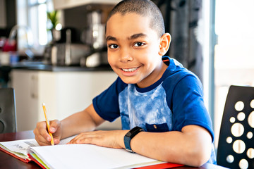 A male black child doing homework at home