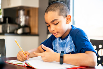 Naklejka na ściany i meble A male black child doing homework at home