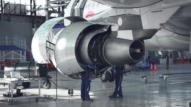 Maintenance of aircraft. Repair of the tail of the aircraft. The engineer repairing the aircraft.. 4k.