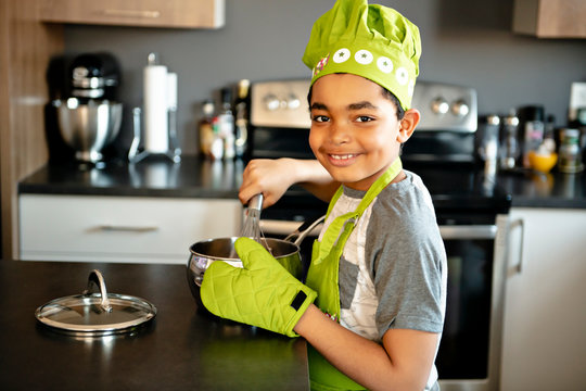 A Nice little kid in chef hat at kitchen