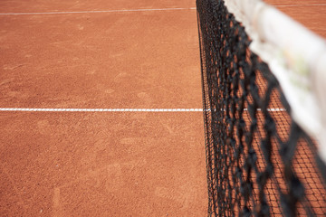 Tennis net on red sand field