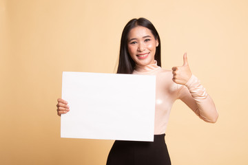 Fototapeta premium Young Asian woman show thumbs up with white blank sign.