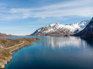 Fototapeta na wymiar Road along fjord and mountain with snow cap in Norway