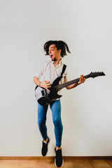 Guitarist posing with his electric guitar, white background.