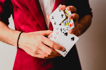 Young magician juggling a deck of playing cards.