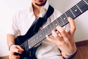 Obraz premium Close-up of the hands of a guitarist performing a song while pressing the strings.