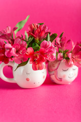 Unicorn mugs with Alstroemeria on bright pink background. Idea of Girly settings. Vivid postcard for any holidays