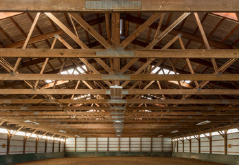 Wooden rafters in indoor horse riding ring