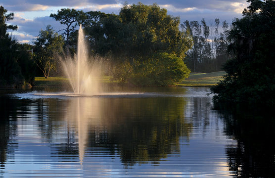 Fountain splashing in still lake