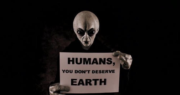 Grey alien creature has messages for human. posing in front of the camera