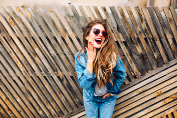 Pretty hipster girl in stylish glasses posing with surprised and excited expression on face. Lovely...