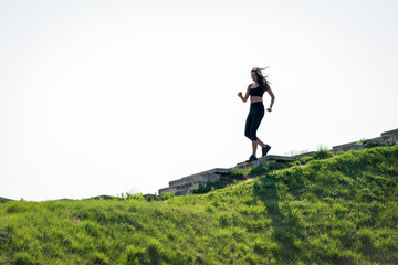 Slender beautiful girl with dark hair runs down the stairs, a symbol of healthy lifestyles, a strong leader and healthy competition