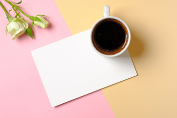 Obraz na płótnie Canvas Blank paper card with copy space, cup of coffee and white roses flowers on colorful background. Concept of love, tenderness, morning breakfast, dating, freshness. Beauty blogger desk. Minimal design.