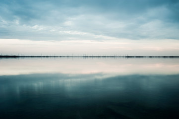 Clouds reflected in still rural lake