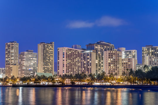 Illuminated city skyline on waterfront, Honolulu, Hawaii, United States