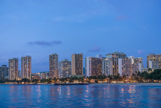 Illuminated city skyline on waterfront, Honolulu, Hawaii, United States