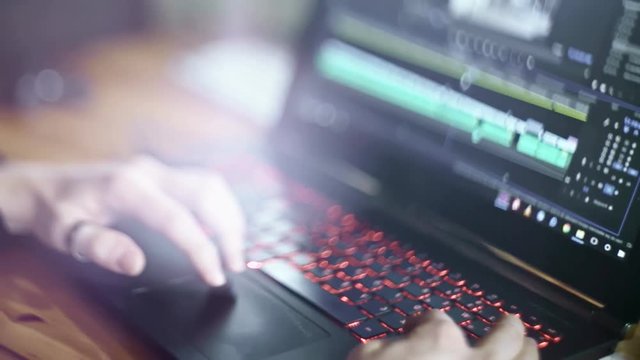 Young man edits his home video on a laptop