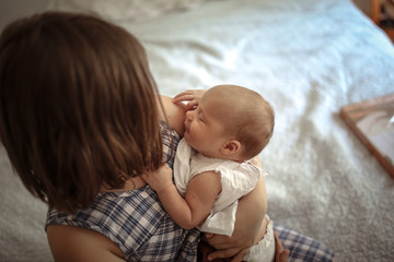 Older sister with baby 1 month, hugging newborn