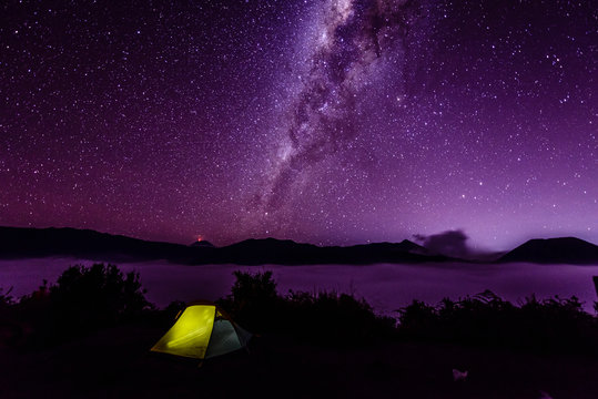 Milky Way galaxy over campsite in starry night sky