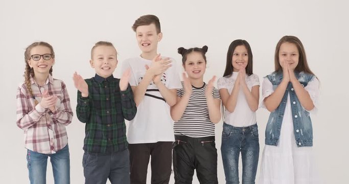 Happy children clapping together in studio