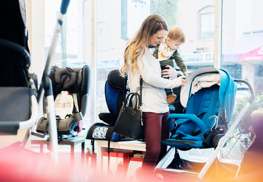 Caucasian mother and baby son shopping in stroller store