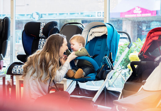 Caucasian mother and baby son shopping in stroller store