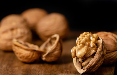 Open wallnuts closeup macro, black background on a wooden surface