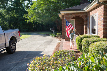 5 year old boy holding American flag outside home, Norristown, Georgia