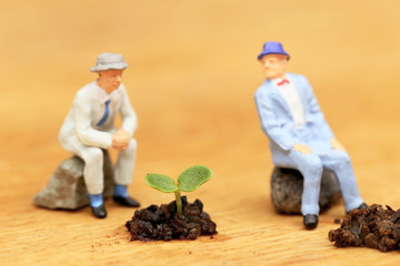植物の成長を見る二人のビジネスマン　成功と失敗