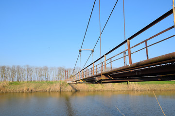 Steel bridge and gas pipeline through irrigation canal.