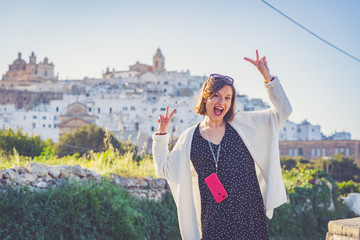 beautiful girl travelling in south of italy take photo selfie in the streets of Ostuni, Apulia,...