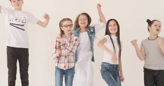 Happy children dancing and jumping in studio