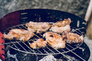 Close up on pork meat cooking on the barbeque outdoor grill food