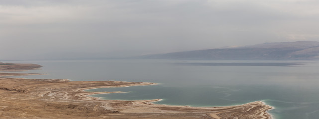Beautiful aerial panoramic view of a mountain desert landscape and dead sea during a cloudy and...
