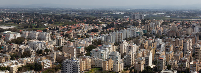 Aerial view of a residential neighborhood in a city during a cloudy and sunny day. Taken in Netanya, Center District, Israel.