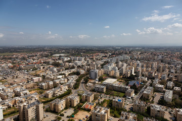 Aerial view of a residential neighborhood in a city during a cloudy and sunny day. Taken in Netanya, Center District, Israel.