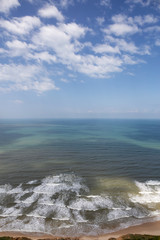 Beautiful aerial view of a sandy beach during a cloudy and sunny day. Taken in Netanya, Center District, Israel.