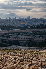 Fototapeta premium Beautiful aerial view of the Old City, Tomb of the Prophets and Dome of the Rock during a sunny and cloudy evening. Taken in Jerusalem, Capital of Israel.