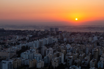 Aerial view of a residential neighborhood in a city during a vibrant and colorful sunrise. Taken in Netanya, Center District, Israel.