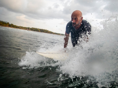 Surfer taking off on a wave